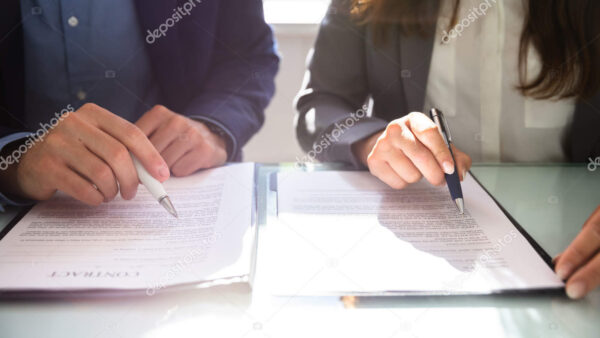 Two Businesspeople Working On Contract Paper