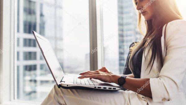 Young woman working on laptop sitting at home.